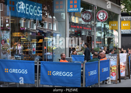 Die Leute draußen sitzen eine Reihe von Cafés und Take-away Läden einschließlich sandwichmaker und Bäckerei Greggs, Mikel Kaffee und Essen. der Tottenham Court Road i Stockfoto