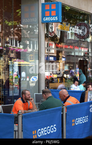 Die Leute draußen sitzen eine Reihe von Cafés und Take-away Läden einschließlich sandwichmaker und Bäckerei Greggs und Mikel Kaffee auf Tottenham Court Road in Cent Stockfoto