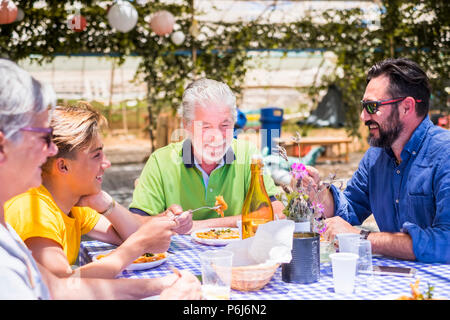 Glückliche Familie zusammen Essen im Restaurant im Freien. Farben und Glück für cacuasian junge und alte Menschen. Sohn, Vater, Großväter genießen Freizeit ein Stockfoto