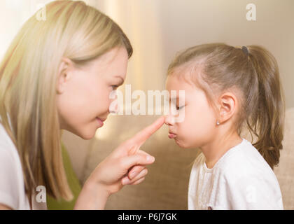 Glücklich liebende Familie. Schöne Mutter tröstet seine junge frustrierte Tochter. Stockfoto