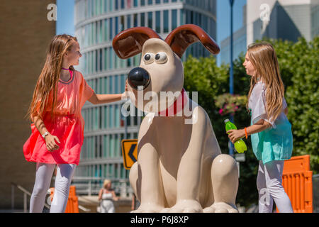 Bristol, UK. 30. Juni 2018 Zwei Mädchen entdecken Sie die Gromit Skulptur an der Temple Quay, Bristol. Die Skulptur ist Teil einer Serie rund um Bristol heute installiert, vor der "Gromit Unleashed 2' Weg, der sich am Montag auf den Markt kommen wird. Der Weg der Kunst läuft über Bristol bis September Geld für Bristols Children's Hospital zu erhöhen. Credit: Paul Hennell/Alamy leben Nachrichten Stockfoto