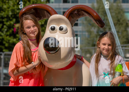 Bristol, UK. 30. Juni 2018 Zwei Mädchen entdecken Sie die Gromit Skulptur an der Temple Quay, Bristol. Die Skulptur ist Teil einer Serie rund um Bristol heute installiert, vor der "Gromit Unleashed 2' Weg, der sich am Montag auf den Markt kommen wird. Der Weg der Kunst läuft über Bristol bis September Geld für Bristols Children's Hospital zu erhöhen. Credit: Paul Hennell/Alamy leben Nachrichten Stockfoto