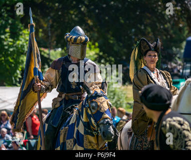 Justing and Medieval Fair im Linlithgow Palace, Linlithgow, Schottland, Großbritannien, 30th. Juni 2018. Historisches Umfeld Schottland beginnt ihr Sommerprogramm mit einer fabelhaften Darstellung mittelalterlicher Jaustings auf dem Gelände des historischen Schlosses. Das Jousting wird von Les Amis D'Onno Equine Stunt Team durchgeführt. Ein Ritter mit Helm auf einem Pferd und eine mittelalterliche Dame auf einem weißen Pferd Stockfoto