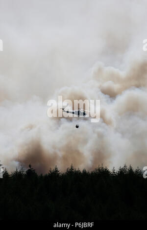 Winter Hill, Bolton, Großbritannien. 30 Jun, 2018. Dramatische Schuß gegen den Rauch von einem Hubschrauber aus das Feuer im Winter Hill Bolton. Quelle: Michael Rawsterne/Alamy leben Nachrichten Stockfoto