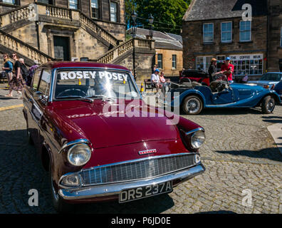 Das Kreuz, Kirkgate, Linlithgow, West Lothian, Schottland, Vereinigtes Königreich, 30. Juni 2018. Enthusiasten Anzeige glitzernde Oldtimer auf einer Kundgebung an einem sonnigen Tag im Sommer. Ein kastanienbraunes 1961 altmodisch Ford Anglia mit Rosey Posey name Banner auf der Frontscheibe Stockfoto