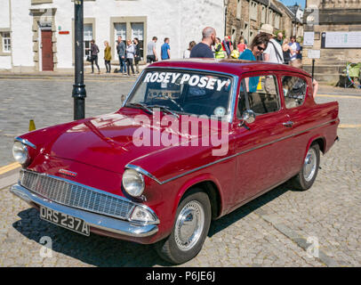 Das Kreuz, Kirkgate, Linlithgow, West Lothian, Schottland, Vereinigtes Königreich, 30. Juni 2018. Enthusiasten Anzeige glitzernde Oldtimer auf einer Kundgebung an einem sonnigen Tag im Sommer. Ein kastanienbraunes 1961 altmodisch Ford Anglia mit Rosey Posey name Banner auf der Frontscheibe Stockfoto