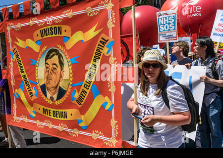 Juni 30, 2018, London, UK. 30. Juni 2018. Lewisham Krankenhaus Unison Banner mit einem Porträt von Nye Bevan außerhalb der BBC warten auf den Marsch durch London von der BBC zu einer Kundgebung in der Nähe von Downing St bis 70 Jahre des NHS zu feiern und seine engagierten Mitarbeiter in anspruchsvollen eines staatlichen NHS, die für alle mit der richtigen Finanzierung und Personalausstattung ist kostenlos und bietet eine erstklassige Services für jede Gemeinschaft zu unterstützen. Der Protest von der Volksversammlung, Gesundheit Kampagnen zusammen, Trades Union Congress, Unison, Vereinen, GMB, British Medical Association, Royal College der Krankenpflege organisiert Stockfoto