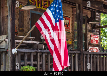 Amerikanische Flagge auf der Veranda eines antiken Shop in den Ausläufern der Blue Ridge Mountains. (USA) Stockfoto