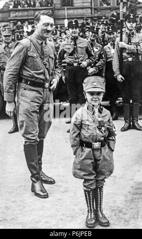 Adolf Hitler ein Lächeln, ein kleiner Junge in Naziuniformen während der Rallye für die Nsdap gekleidet. Stockfoto