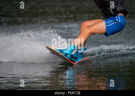 Männliche wakeboarder Fahrten auf See in Wakeboard Spritzwasser Stockfoto