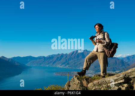 Frau nimmt Bilder von Berg übersehen im Tessin, Schweiz. Stockfoto