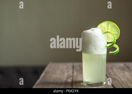 Ei Gin Fizz Cocktail mit Limetten Garnieren auf Holztisch, kopieren. Stockfoto