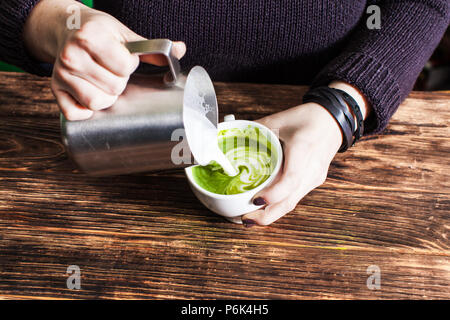 Prozess der Abfüllung von Milch in Matcha Schale Stockfoto