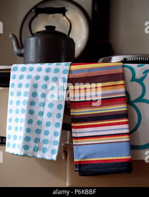 Nahaufnahme der Blaupunktrochen und bunten striped Tee - Handtücher auf Aga Backofen mit schwarzer Wasserkocher Stockfoto