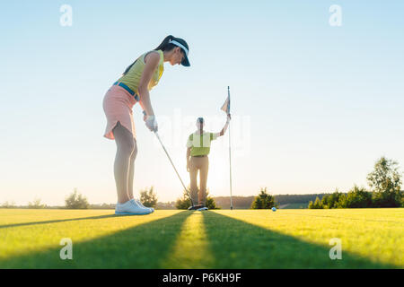 Passende Frau Ausübung schlagen Technik während der Golf Klasse Stockfoto