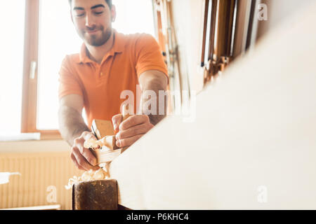 Junge Tischler arbeiten mit Holz Planer Stockfoto