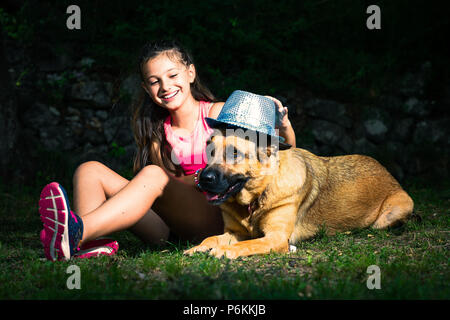 Ein kleines Mädchen spielt mit ihrem Schäferhund. Stockfoto