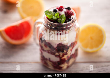 Joghurt mit Müsli und Beeren in kleinen Glas Schale Stockfoto
