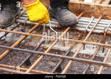 Der Arbeitnehmer Beziehungen stahl Verstärkung mit Kabel der Stiftung zu stärken. Close-up. Tageslicht. Stockfoto