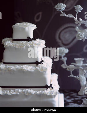 In der Nähe von vier Tier weiß iced Hochzeitstorte mit schwarzen Band eingerichtet Stockfoto