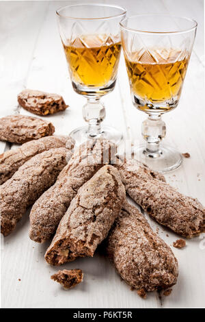 Toskana Italienische Cookies und zwei Gläser vinsanto Dessertwein auf hölzernen weissen Tisch Stockfoto