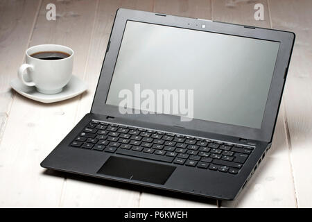 Computer Laptop und Tasse Kaffee auf hölzernen Schreibtisch Stockfoto