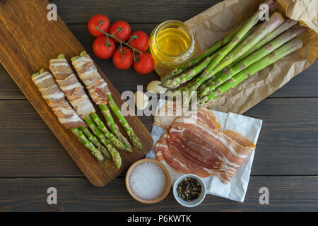 Frische organische Spargel in Parma Schinken auf einem Schneidebrett gewickelt Stockfoto