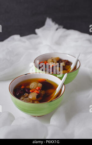 Rotes Datum Longan Suppe. Chinesischer Nachtisch in grün Schüssel. Zwei Schüsseln. Stockfoto