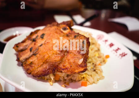 Schweinekotelett mit gebratenen Reis. Chinesisches Essen. Japanisches Essen Stockfoto