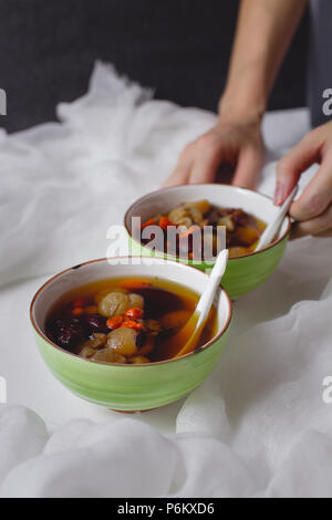 Rotes Datum Longan Suppe. Chinesischer Nachtisch in grün Schüssel. Zwei Schüsseln. Stockfoto