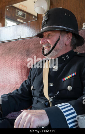 Kidderminster, Großbritannien. Juli 2018. Eine Zeitreise geht bei der Severn Valley Railway weiter, während wir die Uhr wieder in die 1940er Jahre drehen. Besucher und Mitarbeiter ziehen alle Register, um sicherzustellen, dass ein realistischer zweiter Weltkrieg Großbritannien auf dieser historischen Eisenbahnlinie erlebt wird. Ein Vintage Polizist, im Inneren Vintage Eisenbahnwagen, in Helm & volle Polizeiuniform schwellend, sorgt dafür, dass ein britischer Bobby immer präsent ist. Kredit: Lee Hudson/Alamy Live News Stockfoto