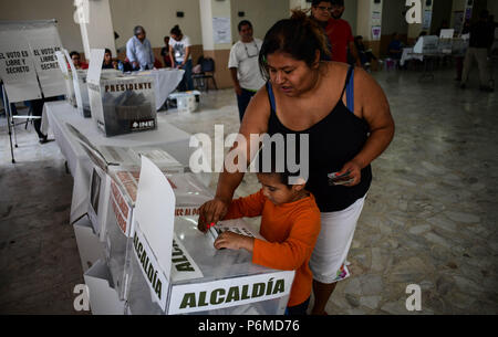 Mexiko, Mexiko City, Mexiko. 1. Juli 2018. DINA ALBNERTO RODRIGUEZ, wirft ihr Votum für die Bürgermeister mit etwas Hilfe von Son VICENTE, 5, an einer Umfrage station in Mexiko City am Sonntag. Mexiko feiert es größte Wahl in der Geschichte durch die Anzahl der eingetragenen Wähler und die Anzahl der Positionen, um gewählt zu werden. Credit: Miguel Juarez Lugo/ZUMA Draht/Alamy leben Nachrichten Stockfoto