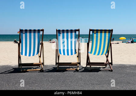 3 Leere Liegestühle in einer einheitlichen Ausbildung, während der Hitzewelle im Juni 2018, auf Sandbänke Strand, Poole, Dorset, Großbritannien Stockfoto