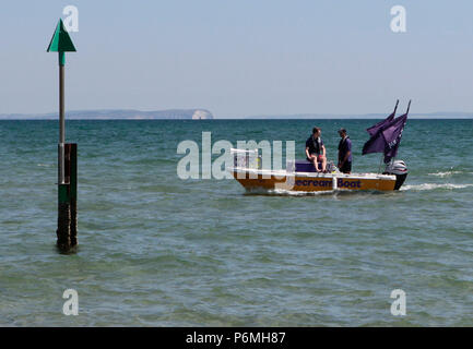 Ein Eis Boot verkauft Eis an Touristen in sehr warmem Wetter 25. Juni 2018 in der Brandung am Strand von Sandbänken, Poole, Dorset, England, Großbritannien Stockfoto