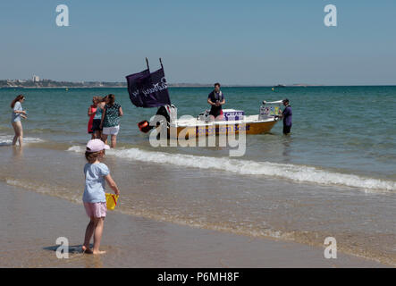 Ein Eis Boot verkauft Eis an Touristen in sehr warmem Wetter 25. Juni 2018 in der Brandung am Strand von Sandbänken, Poole, Dorset, England, Großbritannien Stockfoto