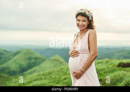 Asiatische schwangere Frau auf natürlichen, grünen Hintergrund Stockfoto