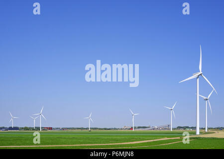 Windkraftanlagen sind in einer grünen Ackerland neben einer Autobahn in Terneuzen Zeeland Niederlande Stockfoto