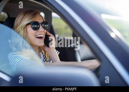 Frau spricht am Telefon im Auto. Stockfoto