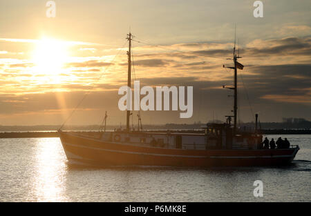 Warnemünde, Fischereifahrzeug bei Sonnenaufgang an der Ostsee Stockfoto