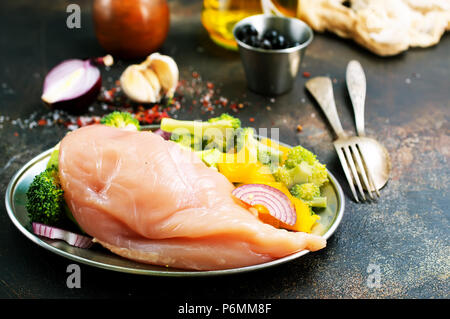 Rohes Hähnchenfilet mit frischem Gemüse auf dem Teller Stockfoto