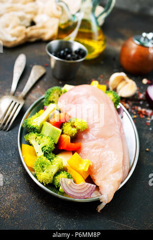 Rohes Hähnchenfilet mit frischem Gemüse auf dem Teller Stockfoto