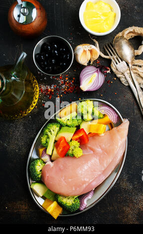 Rohes Hähnchenfilet mit frischem Gemüse auf dem Teller Stockfoto