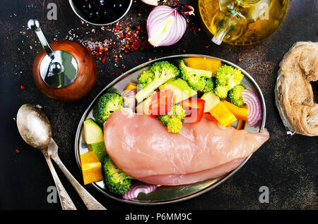 Rohes Hähnchenfilet mit frischem Gemüse auf dem Teller Stockfoto