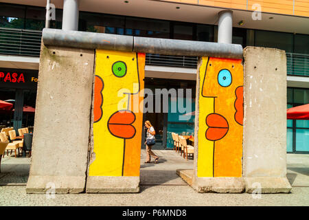 Segment der Überbleibsel der Berliner Mauer mit original Graffiti im öffentlichen Bereich der Innenstadt bereich Mitte angezeigt. Stockfoto