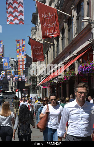 Kunden, Touristen und Mitarbeiter im Büro vorbei das Flaggschiff Hamleys Toy Store in der Regent Street in Central London im Sommer Sonnenschein. Stockfoto