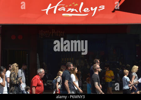 Kunden, Touristen und Mitarbeiter im Büro vorbei das Flaggschiff Hamleys Toy Store in der Regent Street in Central London im Sommer Sonnenschein. Stockfoto