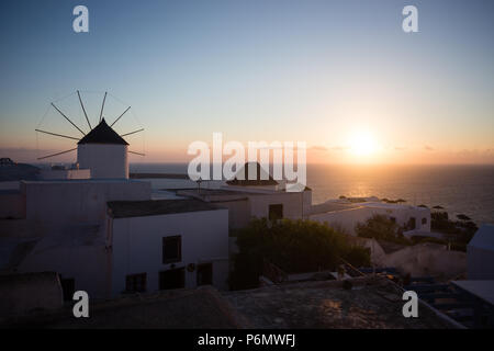 Mykonos, Griechenland. Sonnenuntergang über dem Meer mit berühmten Windmühlen der Griechischen Insel Mikonos, von der Terrasse aus gesehen. Die Kykladen Stockfoto