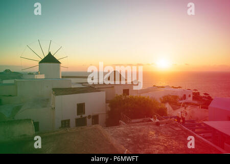 Mykonos, Griechenland. Sonnenuntergang über dem Meer mit berühmten Windmühlen der Griechischen Insel Mikonos, von der Terrasse aus gesehen. Die Kykladen Stockfoto