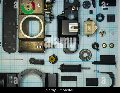 Teile sind vollständig demontiert alten retro Film SLR Kamera auf Millimeterpapier, close-up Stockfoto