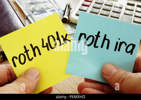 Mann hält Sticks mit Roth 401k vs Roth IRA. Ruhestand. Stockfoto